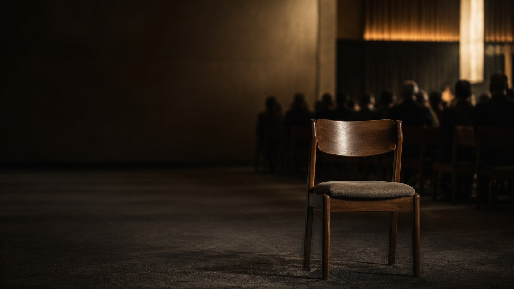 An empty wooden chair set apart in a church gathering